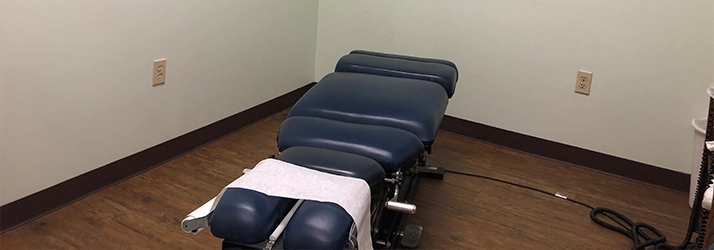 Blue Chiropractic Adjustment Table In Room With Wooden Floor